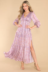 Full body view of this dress that features a v-neckline, sheer long sleeves with elastic cuffs, an elastic waistband, a lining that extends from the shoulder to the mid-thigh, and a slit up the front left side.