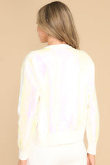 Back view of this sweater that features a crew neckline, iridescent sequins, textured writing, and cuffed long sleeves.