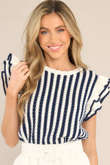 Front view of this top that features a crew neckline, a vertical striped pattern, flutter sleeves, and a slightly scalloped hemline.