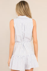 Back view of this blue stripe dress featuring a collared v-neckline, functional buttons, a self-tie waist feature, vertical stripes, and a single tier.