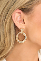 These gold earrings feature a ribbed stud with a connected ribbed hoop with the ribs increasing in size.
