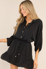 Front view of this romper that features a collared neckline, functional buttons down the front, a self-tie drawstring waist, a lining underneath the shorts, and 3/4 length sleeves.