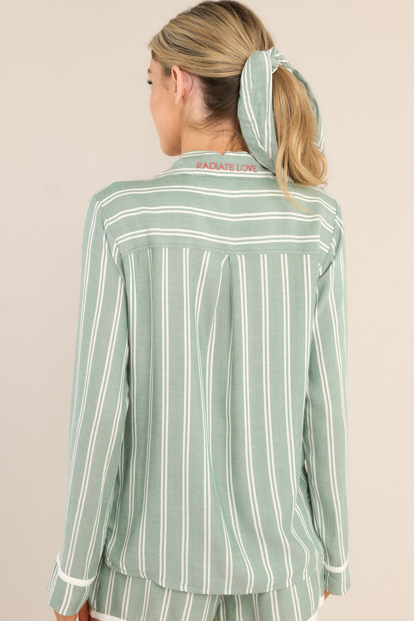 Back view of this PJ top that features a notched lapel collared neckline, a chest pocket, a full button front, and a split hemline.