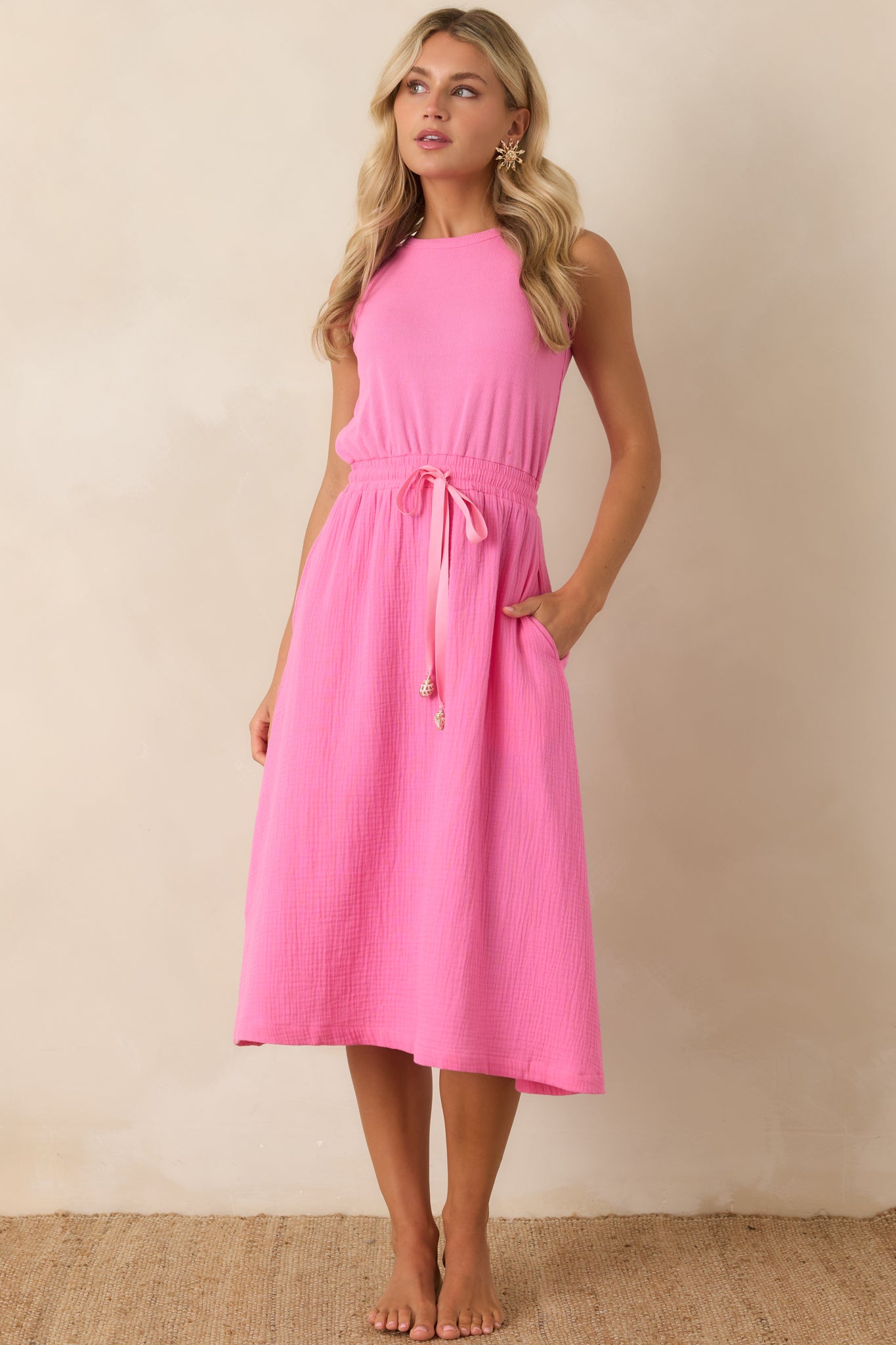 Lightweight midi dress featuring a sleeveless design, elasticized waist, and relaxed silhouette.