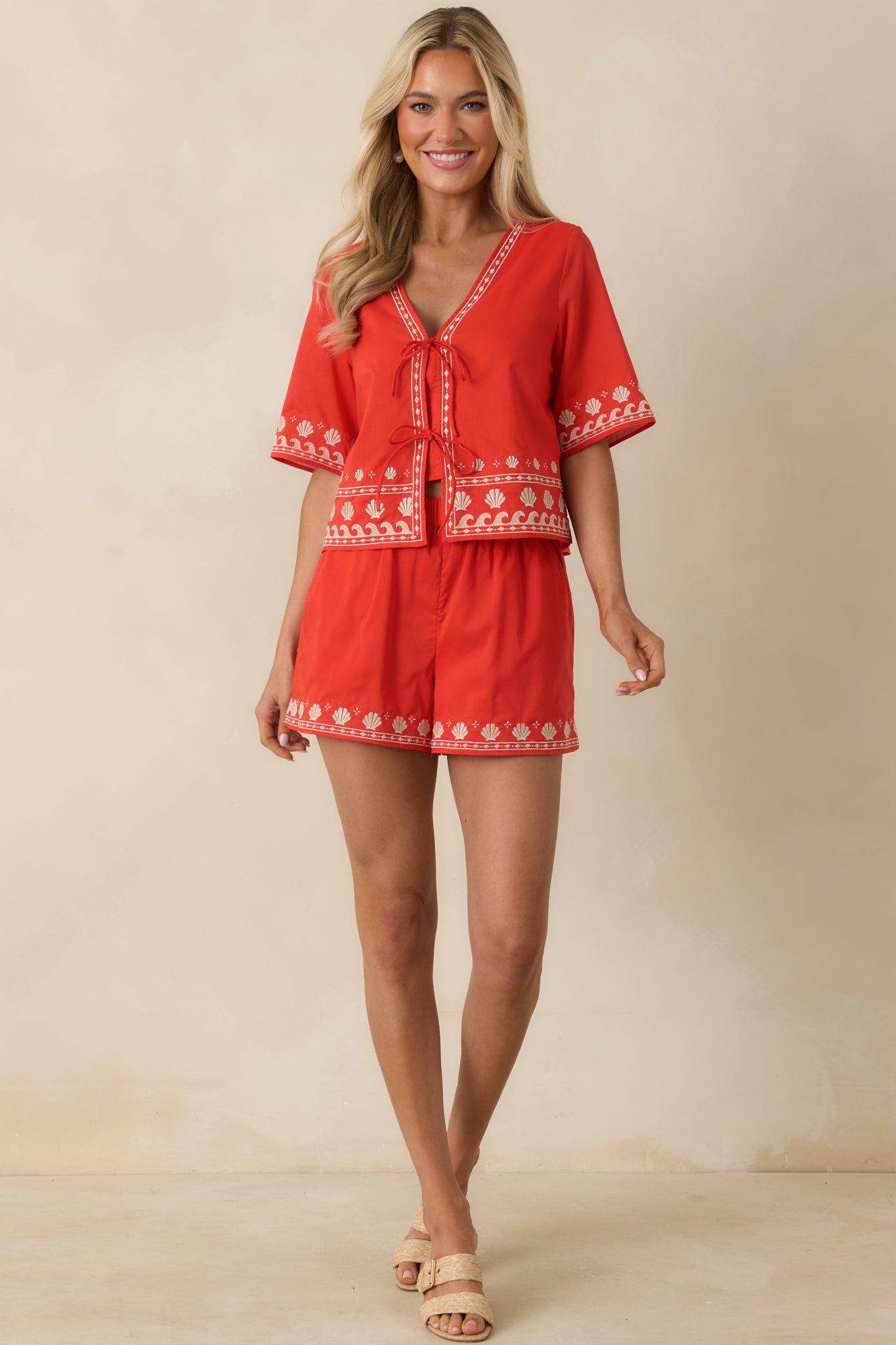 Poppy red embroidered shorts showcasing a comfortable elastic waist, side pockets, and coastal-inspired detailing at the leg openings.