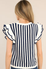 Back view of this top that features a crew neckline, a vertical striped pattern, flutter sleeves, and a slightly scalloped hemline.