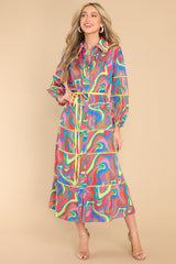 This multi-colored wonderland dress features a collared neckline, functional buttons down the front, a self-tie waist belt, a tiered design, and elastic cuffed long sleeves.