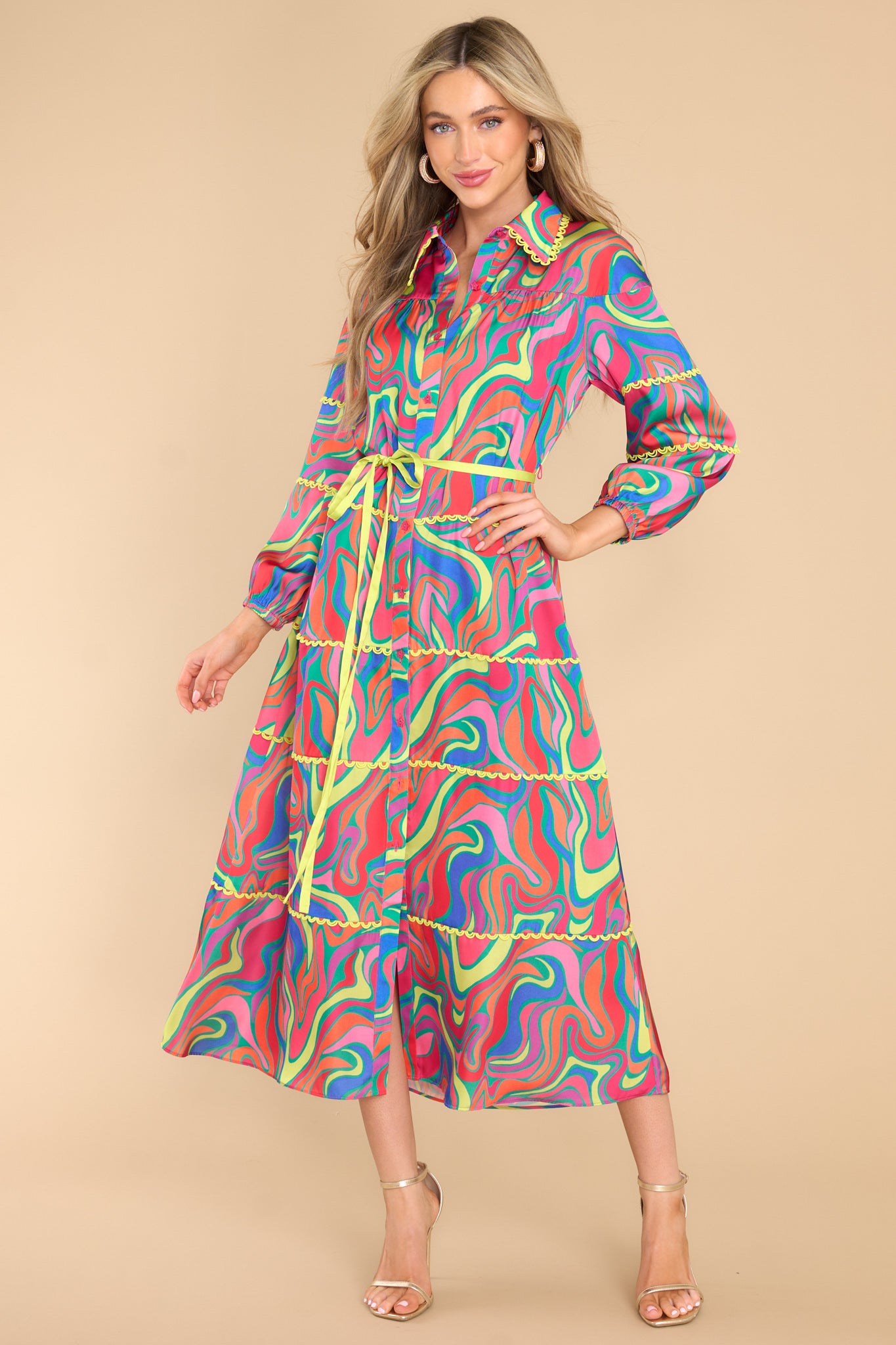 This shot showcases a marbled pattern in the colors pink, orange, yellow, green, blue, and purple with yellow accent trimming throughout the entire dress.