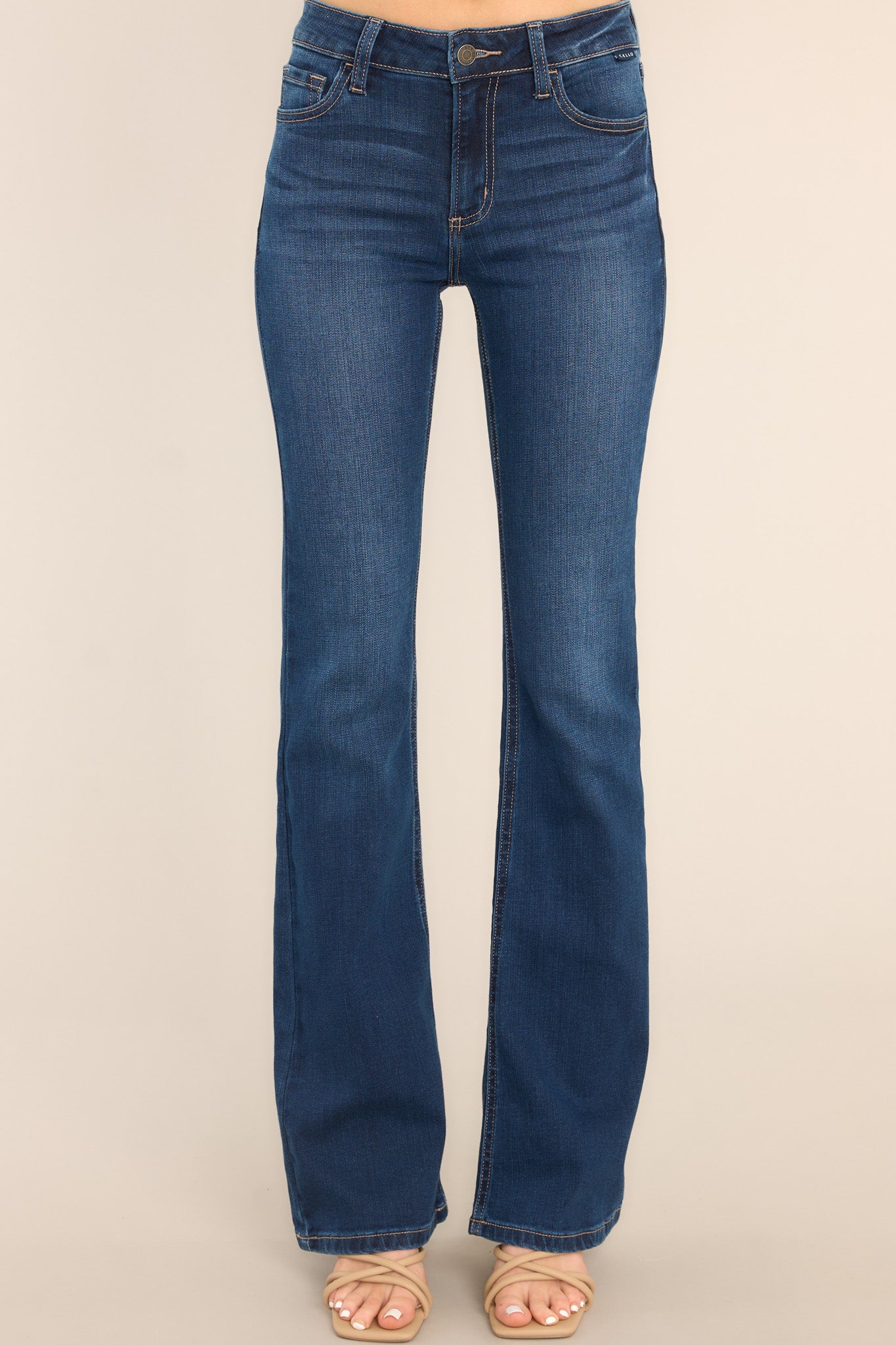 Front view of these jeans that feature a classic button and zipper closure, belt loops, front and back pockets, a flared cut, and a dark wash.