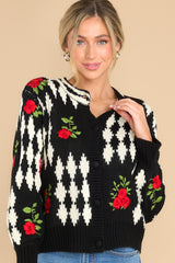Front view of this cardigan that features a scoop ribbed neckline, functional buttons all the way down, and embroidered roses.