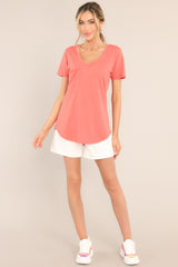 Full body view of this tee that features a v-neckline, a slouched breast pocket, a scooped hemline, and short sleeves.