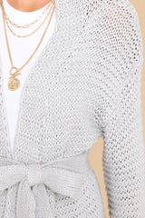 Close up view of this cardigan that features chunky knit fabric and a waist tie.