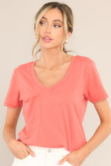 Front view of this tee that features a v-neckline, a slouched breast pocket, a scooped hemline, and short sleeves.