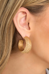 These gold hoops feature gold hardware, a textured material, and a secure post backing.
