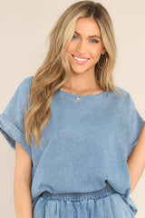 Front view of  this top that features a crew neckline, a denim-like material, and cuffed short sleeves.