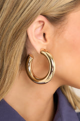 Model shown wearing chunky gold hoop earrings. 