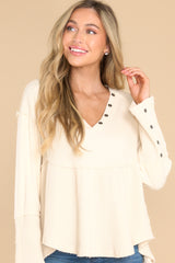 Front view of this top that features a v-neckline with button detailing and button detailing on the sleeves.