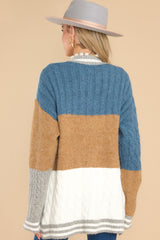 Back view of this cardigan that features a v-neckline, functional buttons down the front, stripe detailing along the hem and cuffs, cable knit detailing, and a soft knit material throughout.