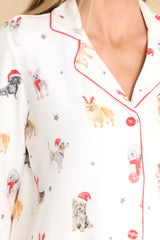 Close up view of this top that features a collared neckline, round red buttons down the front, and a festive print.