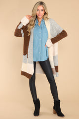 Full body view of this cardigan that features a color block design in shades of brown, grey, and cream.