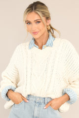 Front view of this sweater that features a ribbed v-neckline, long sleeves with ribbed cuffs, a bottom hem that tapers in, and a chunky knit design throughout.