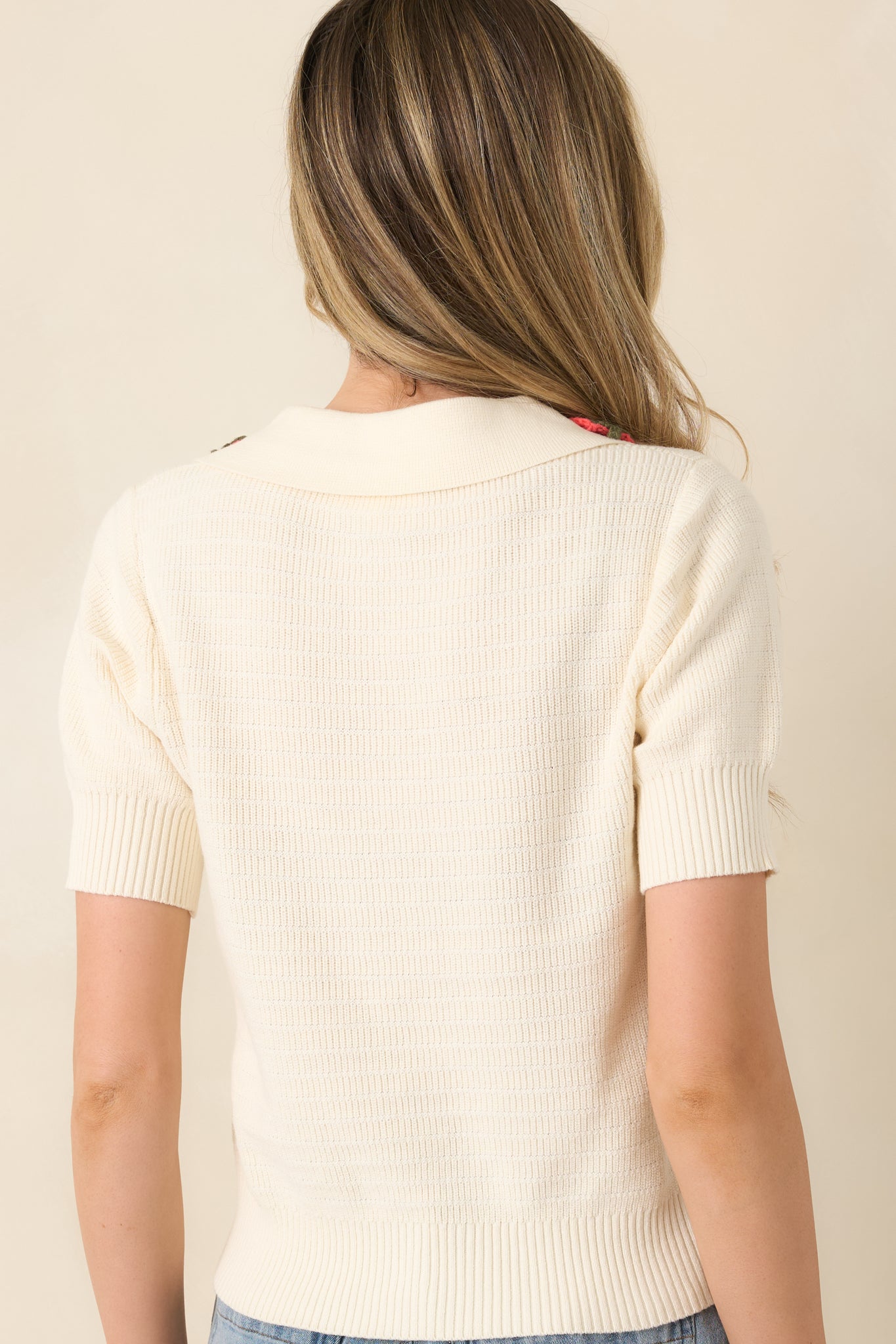 Ivory short-sleeve sweater with clean back silhouette and ribbed hem.