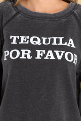 Close up view of this sweatshirt that features a round neckline, long sleeves with ribbed cuffs, a ribbed bottom hem, and tequila-themed graphic lettering on the front and back.