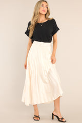 Front view of this maxi skirt that features a high waisted design, a side zipper, belt loops, a functional and removable belt, and pleats throughout.