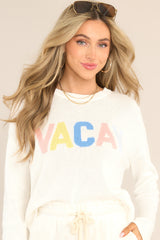 This white sweater features a ribbed crew neckline, dropped shoulders, colorful wording, and a ribbed hemline. 