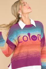 Front view of  this sweater that features shades of purple, blue, and orange.