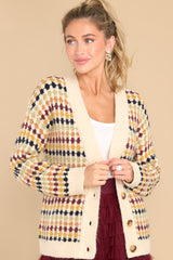 This multi-colored cardigan features a v-neckline, four functional buttons down the front, a ribbed hem, cuffed sleeves, and a fun pattern.