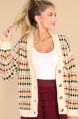 Front view of this cardigan that features a v-neckline, four functional buttons down the front, a ribbed hem, cuffed sleeves, and a fun pattern.