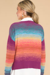 Back view of  this sweater that features a crew neckline, a ribbed hem, cuffed sleeves, and a colorful gradient pattern.