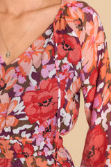 Close up view of this dress that features a v-neckline with a self-tie string, long sleeves, and an elastic waistband.