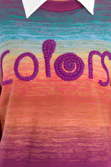 Close up view of this sweater that features a crew neckline, purple lettering that says 