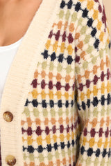 Close up view of this cardigan that features a v-neckline, four functional buttons down the front, a ribbed hem, cuffed sleeves, and a fun pattern.