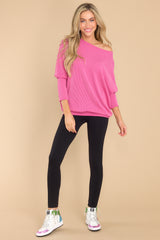 This fuchsia top features a round neckline, long dolman sleeves, and a slight high low hem line. 