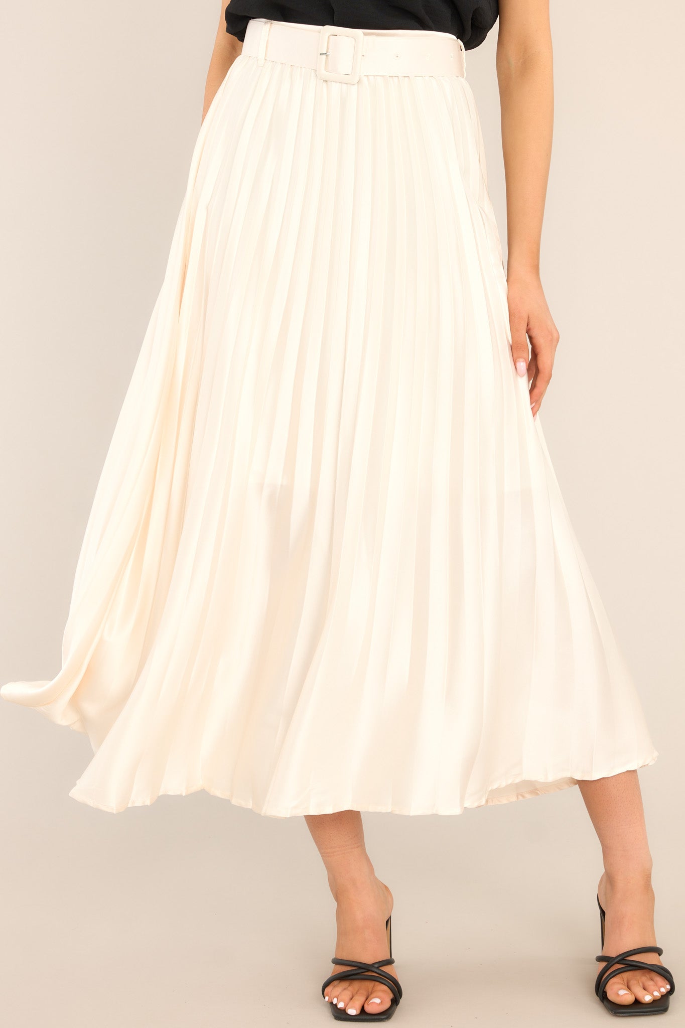 Front view of this maxi skirt that features a high waisted design, a side zipper, belt loops, a functional and removable belt, and pleats throughout. 
