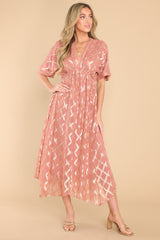 Full body view of this dress that showcases the gold pattern of the pink fabric.
