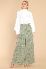 A wide body view of seafoam green pants featuring a high waisted design, a wide leg, a zipper with a hook and bar closure, belt loops, functional pockets, and front pleats.