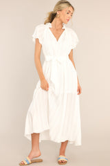 Front view of this dress that features a v-neckline with ruffle detailing and a self-tie feature, a self-tie waist belt, and a flowy skirt.