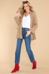 Full body view of  this cardigan that features a folded collar, functional pockets, and side slits.