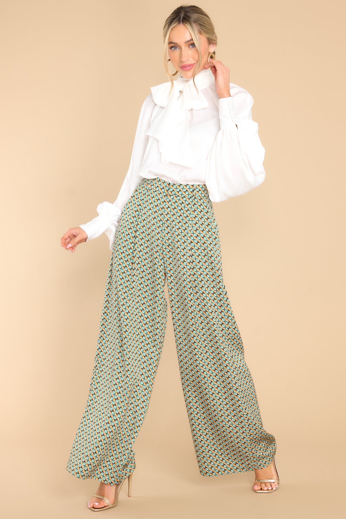A full body view of these seafoam green pants feature a high waisted design, a wide leg, a zipper with a hook and bar closure, belt loops, functional pockets, and front pleats.
