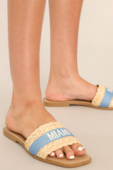 Close up view of these sandals that feature a a strap across the top of the foot with the name of a tropical location.