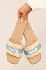 These blue sandals feature a a strap across the top of the foot with the name of a tropical location.