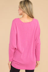 Back view of this top that features a round neckline, long dolman sleeves, and a slight high low hem line.