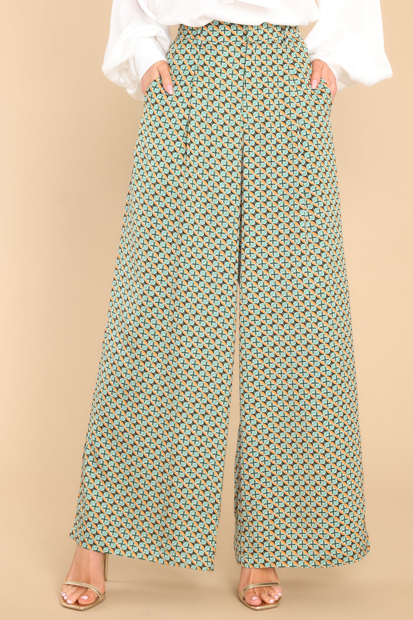 These seafoam green pants feature a high waisted design, a wide leg, a zipper with a hook and bar closure, belt loops, functional pockets, and front pleats.