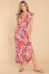 Full body view of this dress that showcases the floral print in shades of pink, red, and orange.