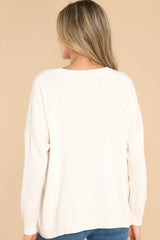 Back view of this sweater that features a crew neckline, a high low hemline, and cuffed sleeves.