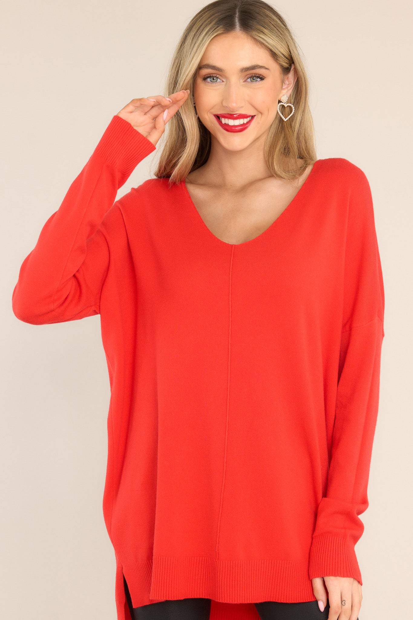Front view of this sweater that features a v-neckline, center seam down the front, a high low hem, and slits on the sides.